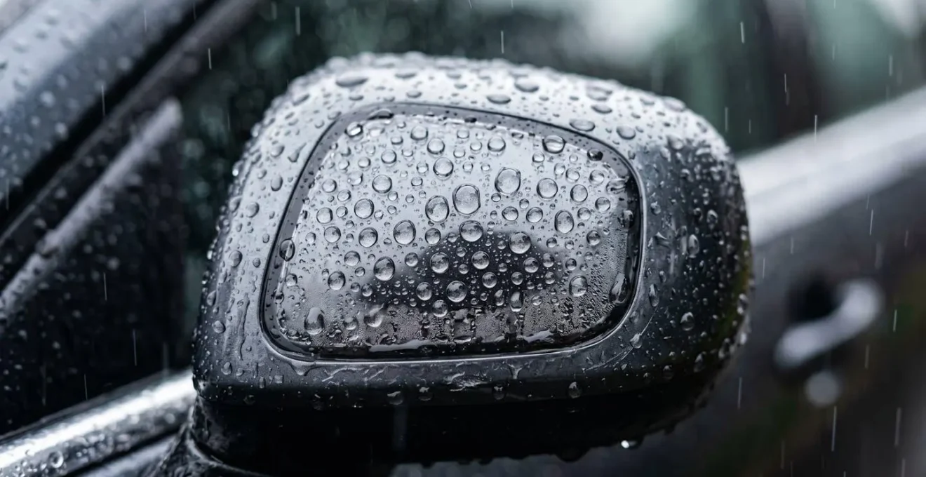 Gros plan sur un capteur radar de voiture recouvert de gouttelettes d'eau par forte pluie