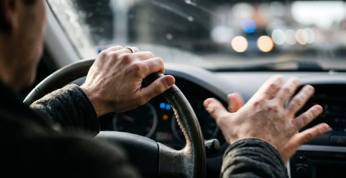 Main floue tenant un volant avec effet de mouvement représentant la perte de contrôle